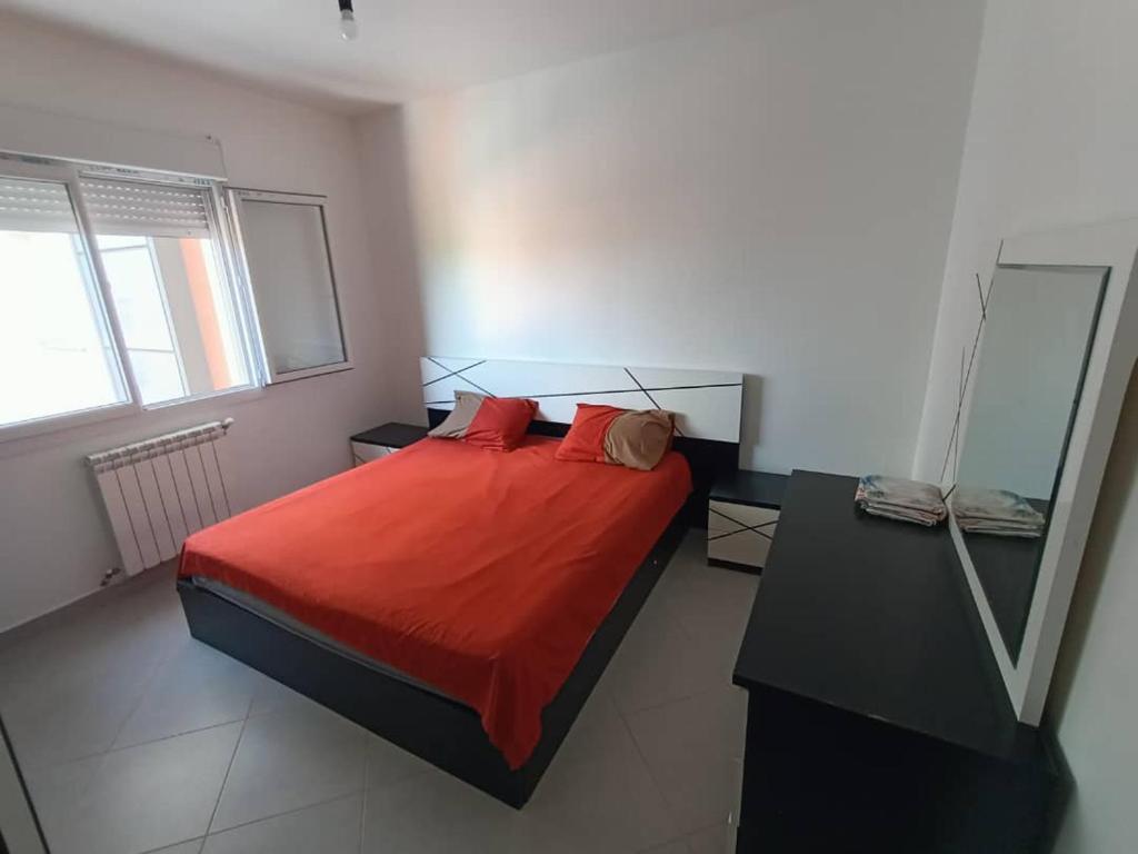 - une chambre avec un lit et une couverture rouge dans l'établissement Bienvenus à Bejaia F3 6p, à Béjaïa