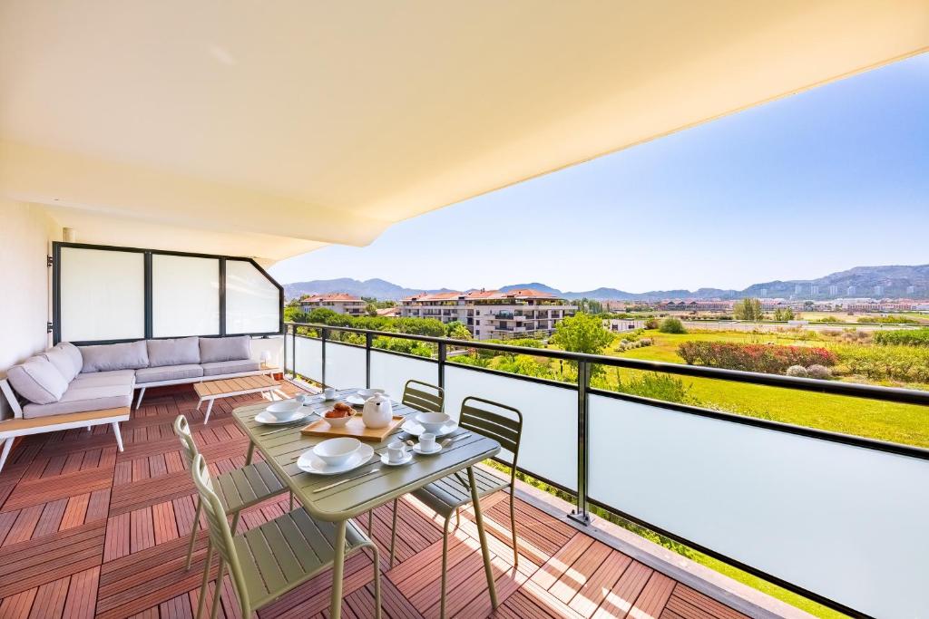 een balkon met een tafel en stoelen en een bank bij Prado Beach - Appt avec terrasse in Marseille