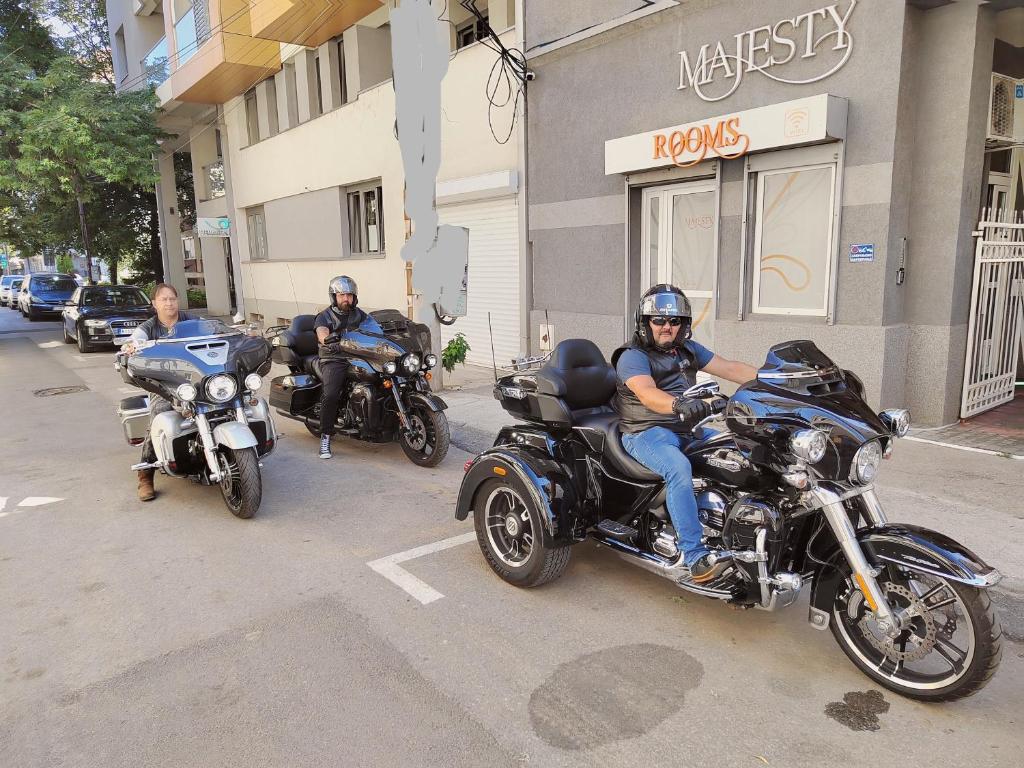 three men riding motorcycles down a city street at Bed and Breakfast Majesty in Niš