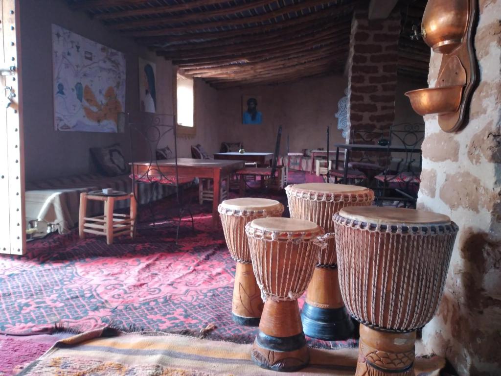 um quarto com um grupo de bancos e uma mesa em Visitors camp em M'hamid