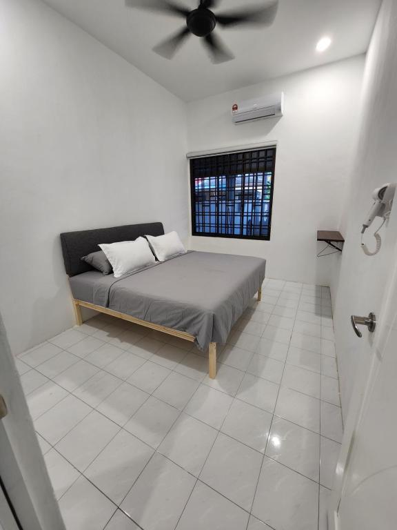 Schlafzimmer mit einem Bett und einem Deckenventilator in der Unterkunft 4 bedroom homestay @ Mersing in Mersing