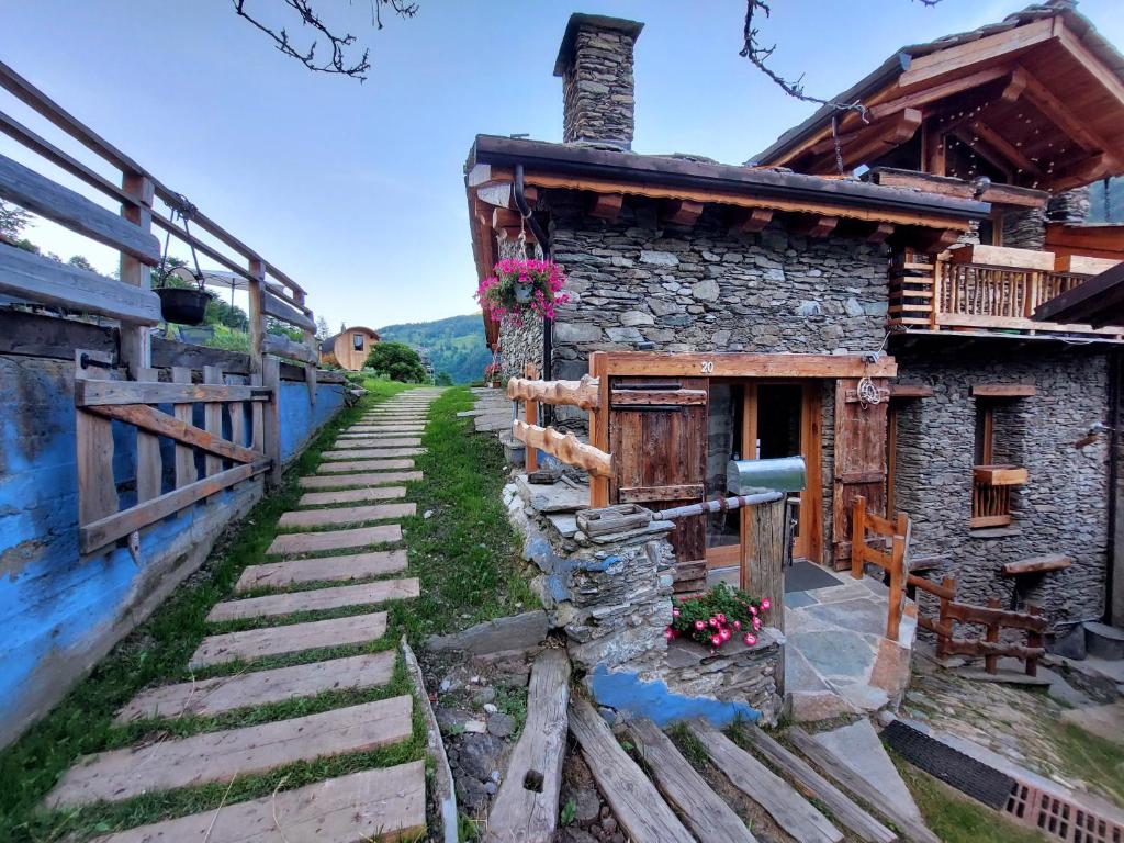 a stone house with a staircase leading up to it at CasAlpAca B&B con sauna a Prali in Prali Villa