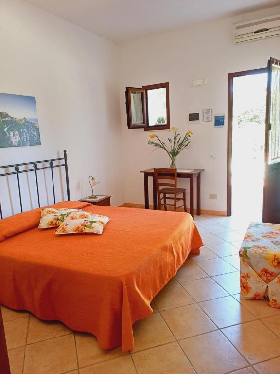 エーリチェにあるLa Mimosa di Ericeのベッドルーム1室(オレンジ色の毛布付きのベッド1台付)