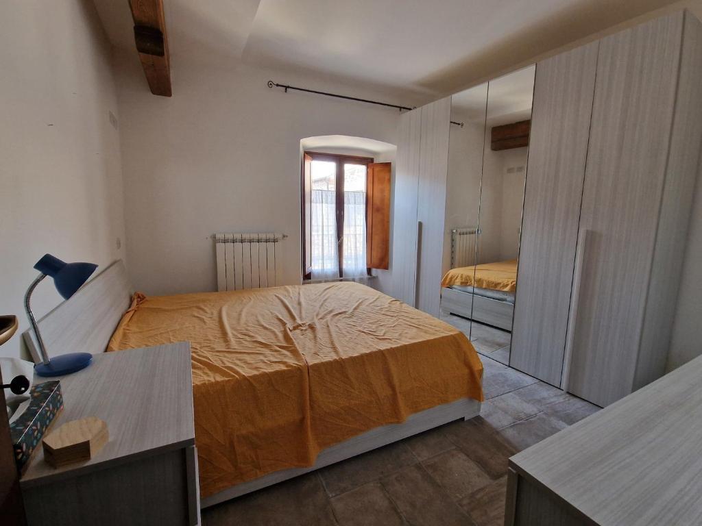 1 dormitorio con cama y espejo en Casa Il Girasole, en Lugnano in Teverina