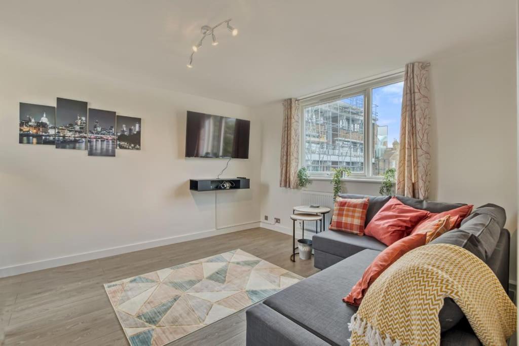 ein Wohnzimmer mit einem Sofa und einem TV in der Unterkunft Hidden Gem in Battersea w/ Free Parking in London