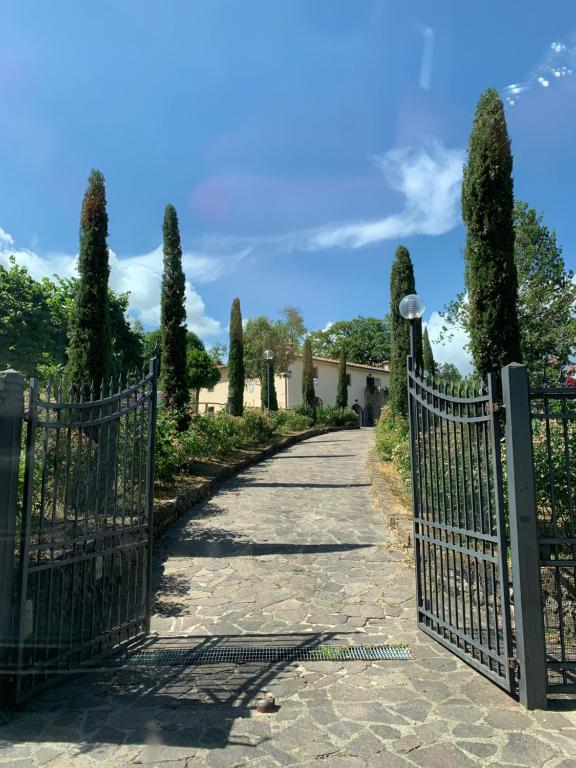 una puerta que conduce a una entrada con árboles y arbustos en Podere del Piccini con piscina in val d Orcia Toscana, en Piancastagnaio
