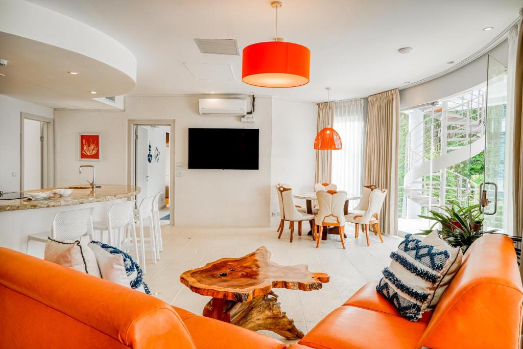 a living room with an orange couch and a table at Hermosa Wave A2 & B2 in Playa Hermosa