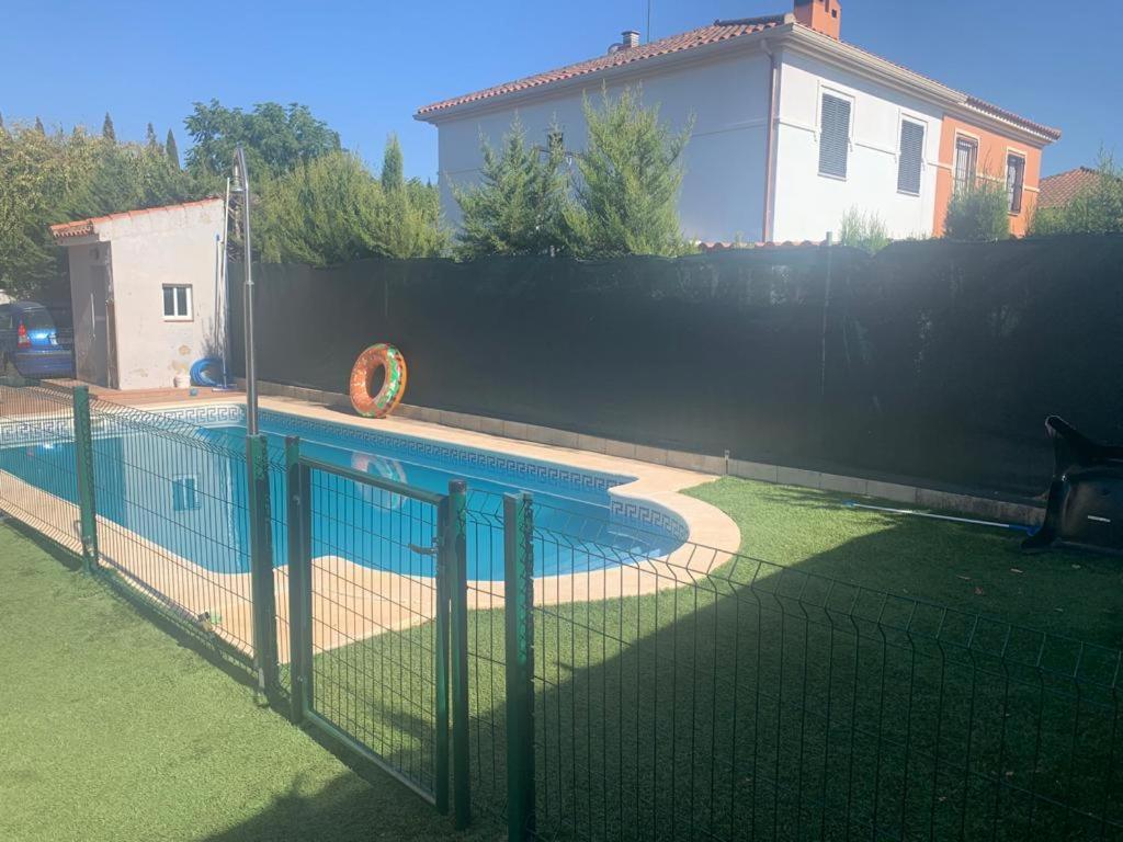 a fence around a swimming pool in a backyard at Villa Almenso in Seville