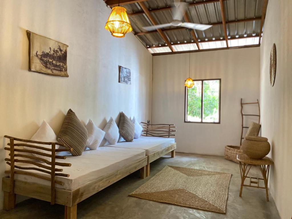 a room with a couch and chairs in it at Kirãmam Villa in Pasikuda
