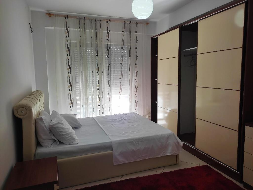 Habitación pequeña con cama y ventana en ALPHA CITY CENTER APARTMENT, en Shkodër