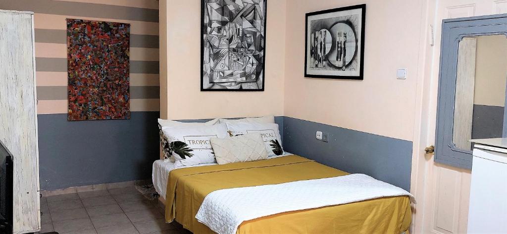 een kleine slaapkamer met een bed en wat foto's aan de muur bij Hanna's Place - Great Location in Eilat