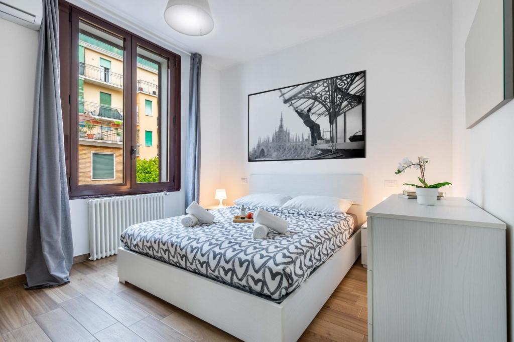 una camera bianca con un letto e una finestra di Divi Apartments - Strategic Place a Milano