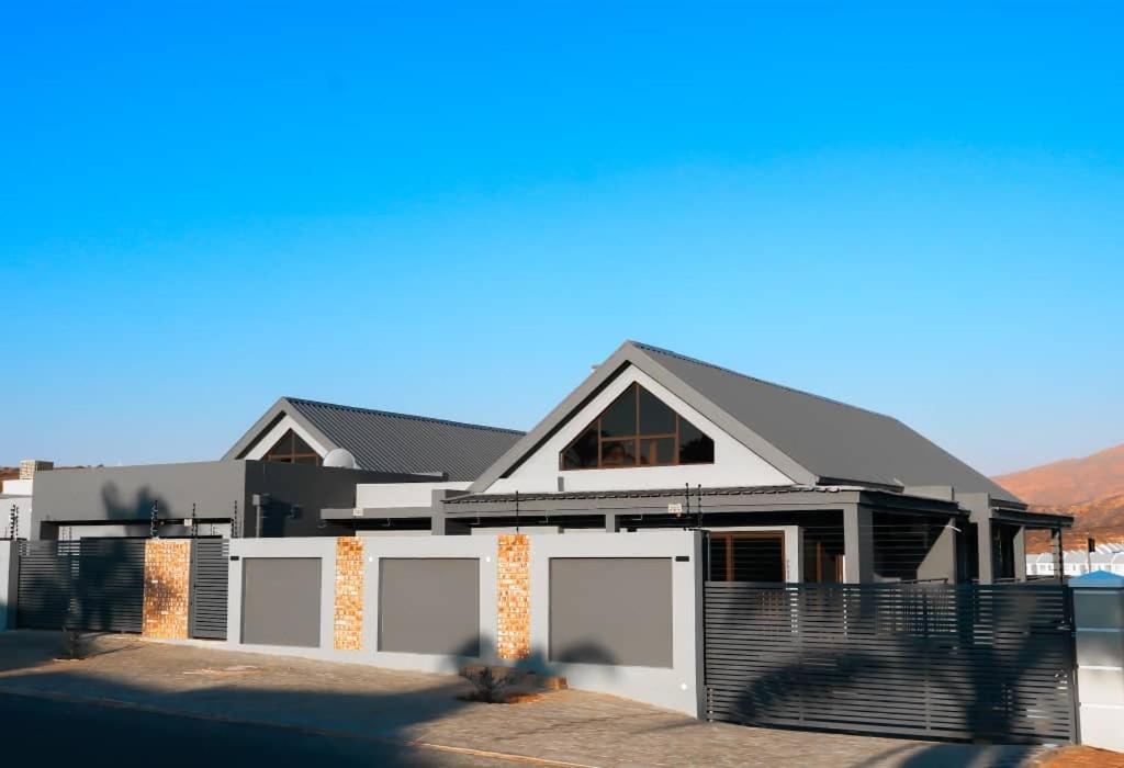 a house with a white fence in front of it at L. A. P Guesthouse in Windhoek