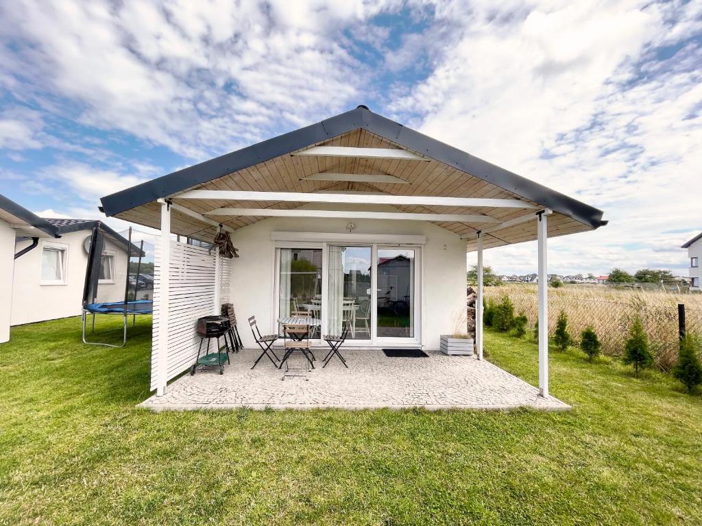 einen Pavillon mit einem Tisch und Stühlen im Hof in der Unterkunft Domki Laba in Łeba