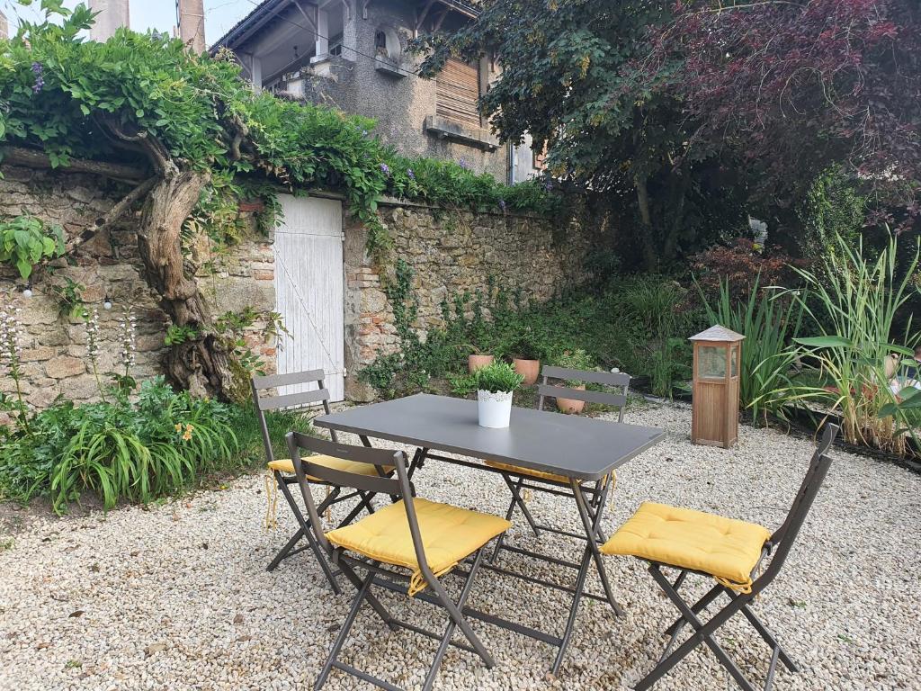 a black table with two chairs and a table with a plant at LES 5 ESCALES in Parthenay