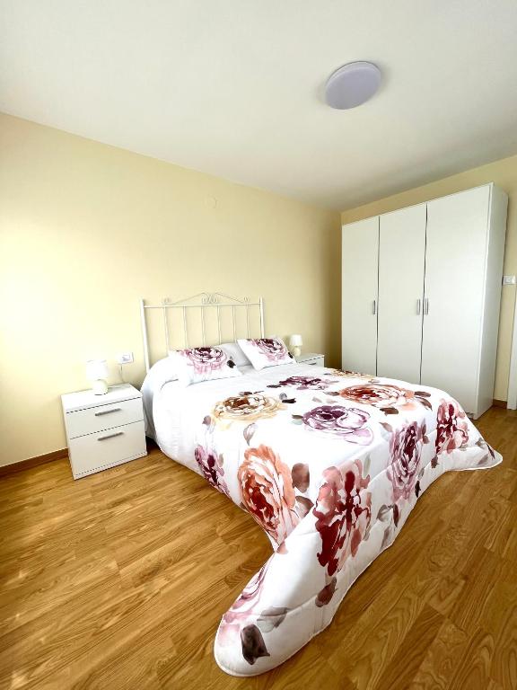 a bedroom with a large bed with a floral blanket at Casa Marina in Cerdido
