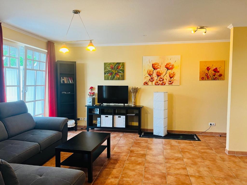 a living room with a couch and a tv at Villa Isabell in Binz