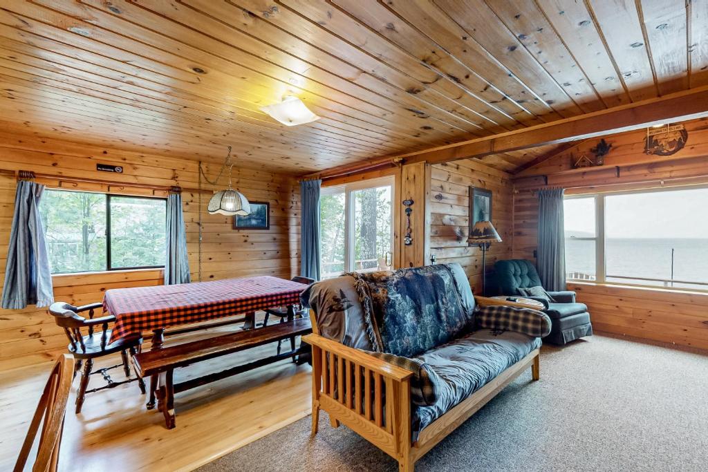 uma sala de estar com um sofá e uma mesa em Lakefront Cabin and Cottages em Greenville