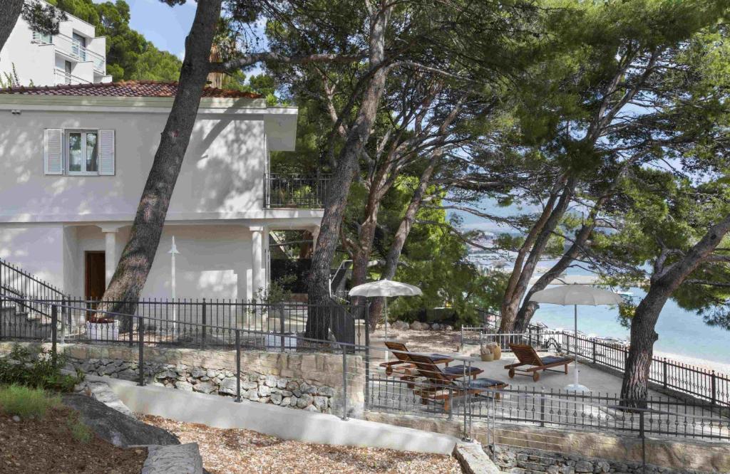 una casa bianca con sedie e ombrelloni sulla spiaggia di Villa Berulia a Brela