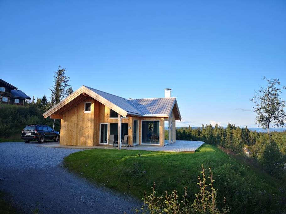 LiagardaneにあるStor og moderne hytte med panoramautsiktの車が停まった家