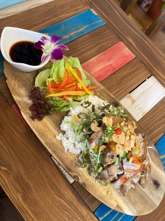 un plato de comida con arroz y verduras en una mesa en Surfer's Cafe& Hostel, en Chatan