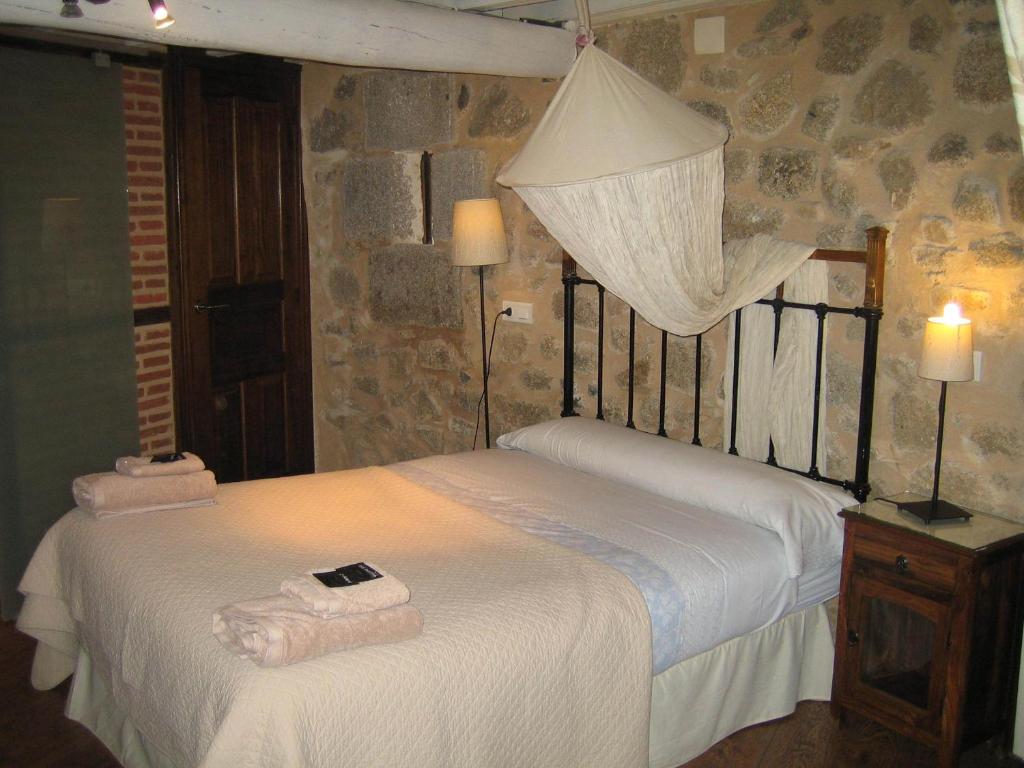 a bedroom with a bed with towels on it at La Serranilla in San Esteban de la Sierra