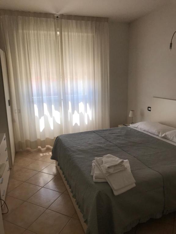 プリンチピナ・ア・マーレにあるResidence il Tomboloのベッドルーム1室(ベッド1台、タオル2枚付)