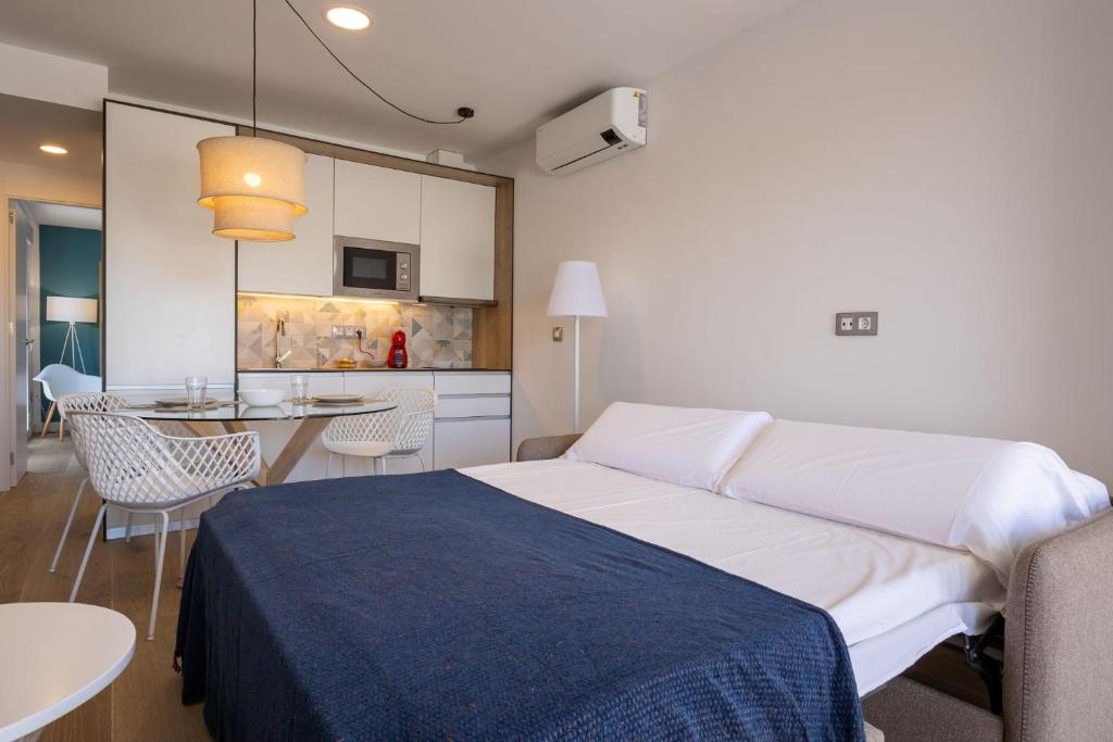 a bedroom with a bed and a table and a kitchen at paqo lodge Laguna del Portil, a 400 metros de la playa in El Portil