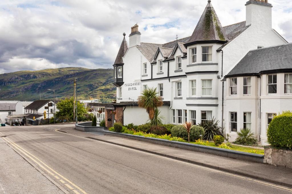 una grande casa bianca sul lato di una strada di Caledonian Hotel 'A Bespoke Hotel’ a Ullapool