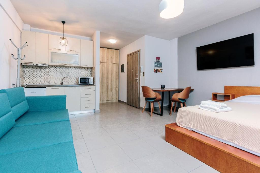 a bedroom with a bed and a kitchen and a table at FAOS Properties in Kavala