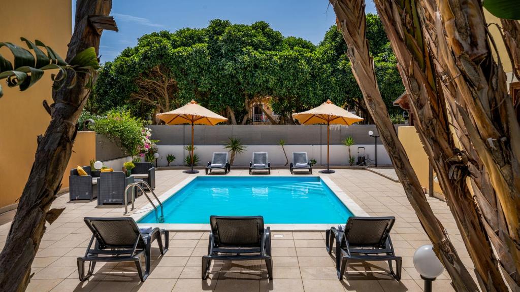 - une piscine avec des chaises et des parasols à côté dans l'établissement Villa delle Sirene 6, Emma Villas, à Valderice