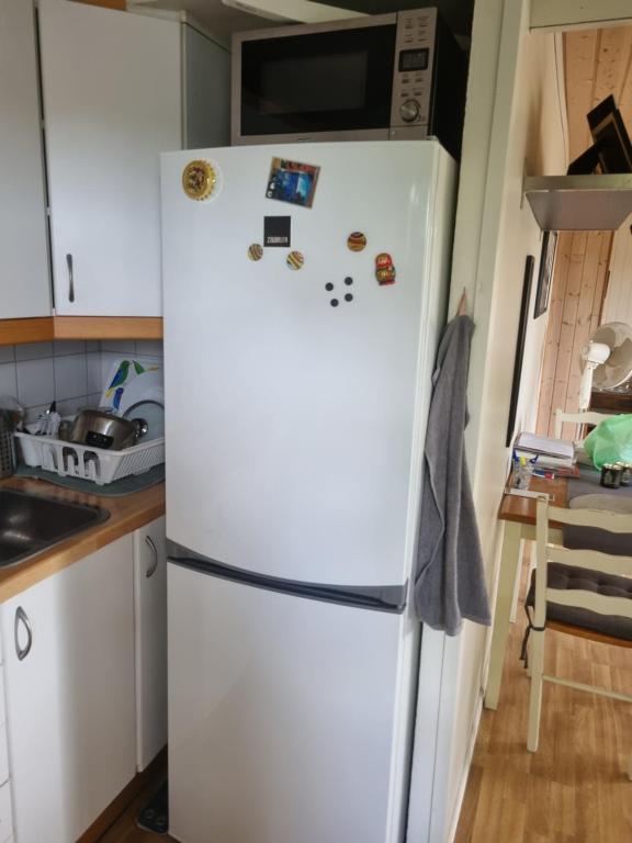 een witte koelkast in een keuken met magneten erop bij Trondheim/Nardo in Trondheim