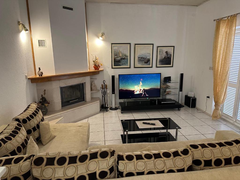 a living room with a couch and a flat screen tv at Apartment Jelić in Duće