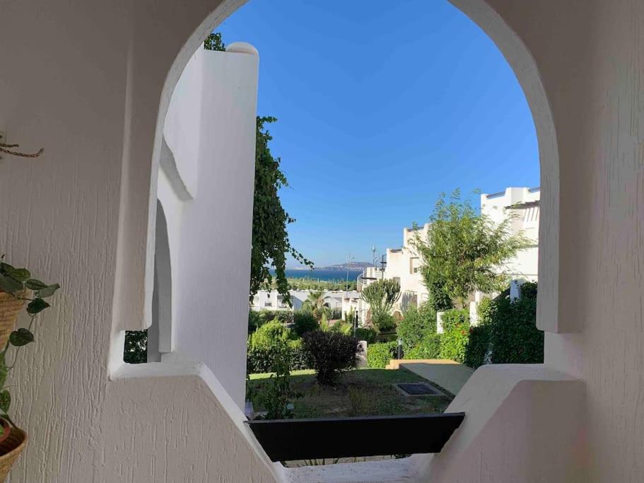 una ventana arqueada en un edificio con vistas en Maison Alcudia Smir, Tetouan, Mer Méditerranée, en Fnidek