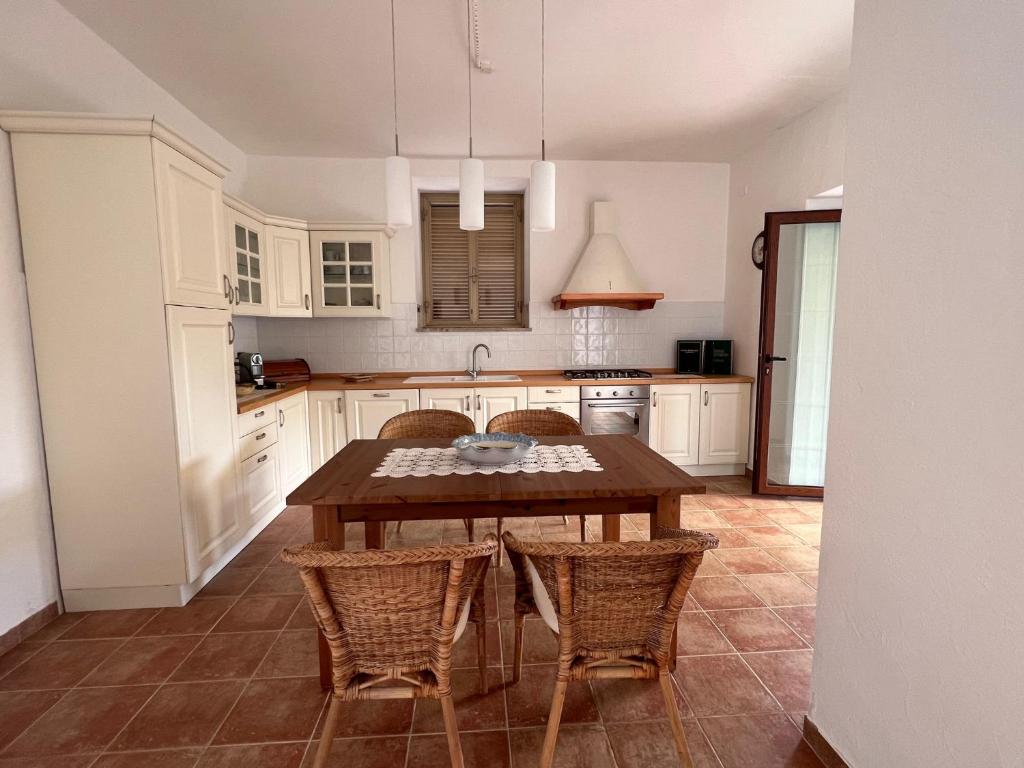 cocina con mesa de madera y sillas en Panorama Mare e Monti, en Spigno Saturnia