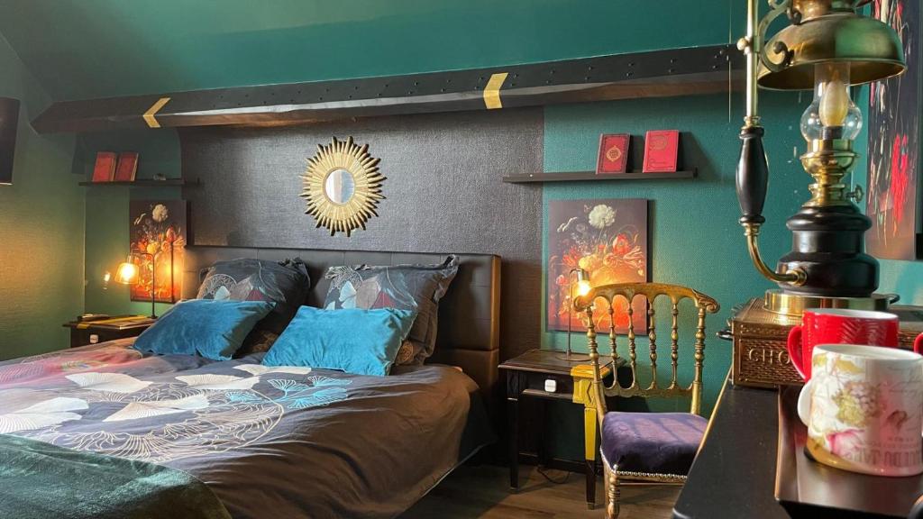 ein Schlafzimmer mit einem Bett und einem Tisch mit einer Lampe in der Unterkunft les nuits victoriennes in Saint-Germain-du-Corbéis