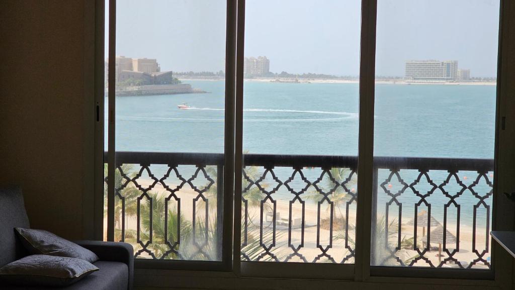 a room with a view of the ocean from a balcony at Sea view near the beach 2 in Ras al Khaimah