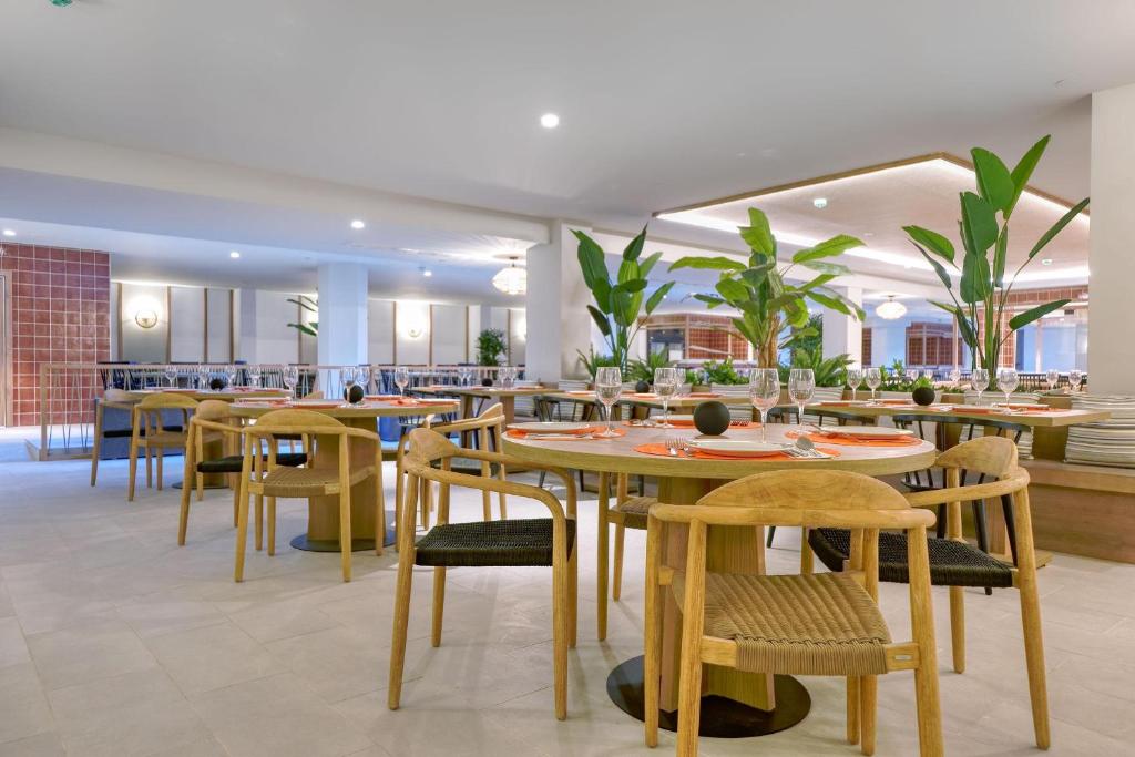 a restaurant with wooden tables and chairs and plants at HOVIMA Suites Costa Adeje in Adeje
