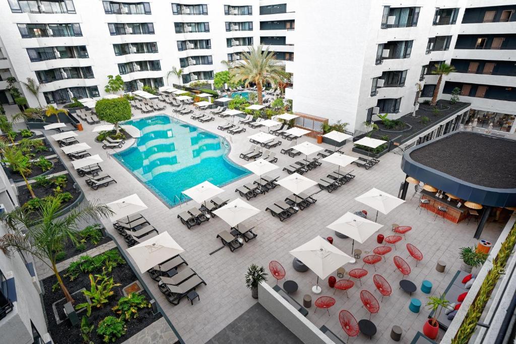 an overhead view of a pool with tables and chairs at HOVIMA Suites Costa Adeje in Adeje