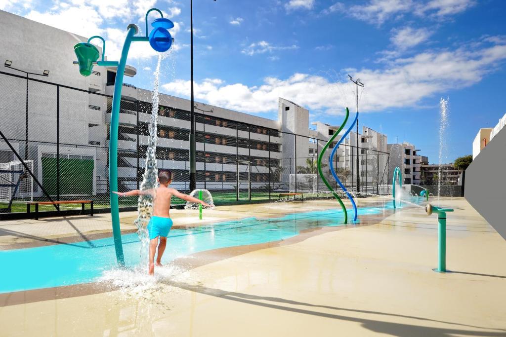 a young boy playing in a water park at HOVIMA Suites Costa Adeje in Adeje