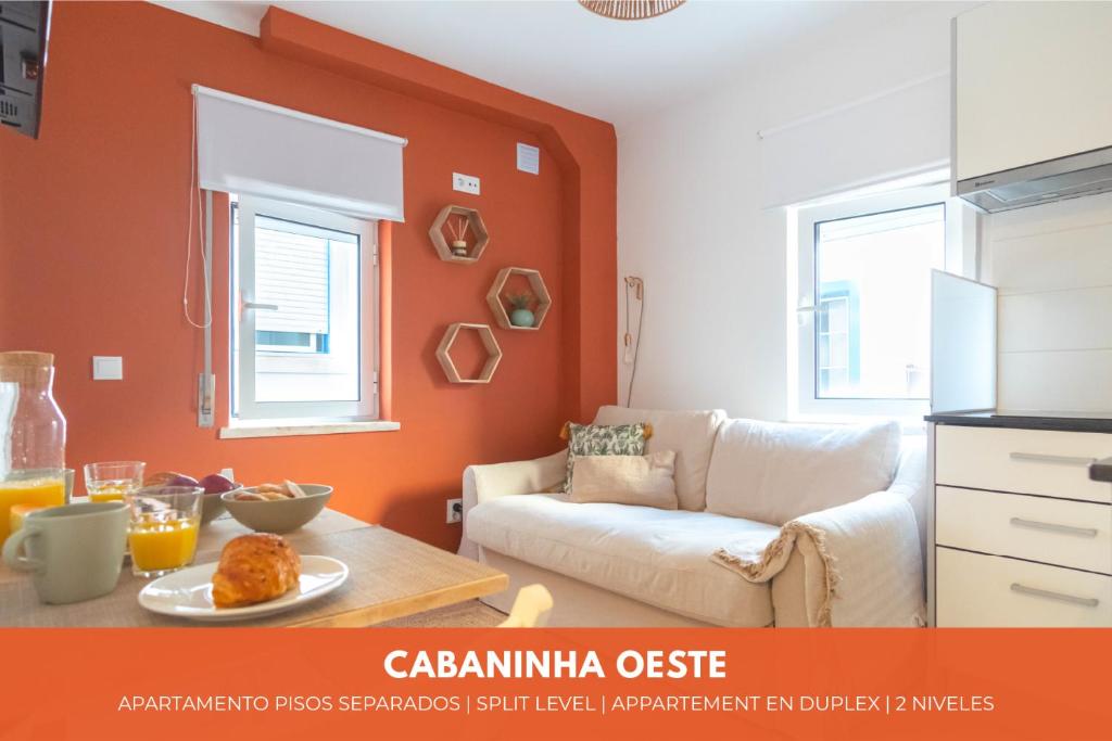 sala de estar con paredes de color naranja y sofá en Cabanas do avô João, en Nazaré