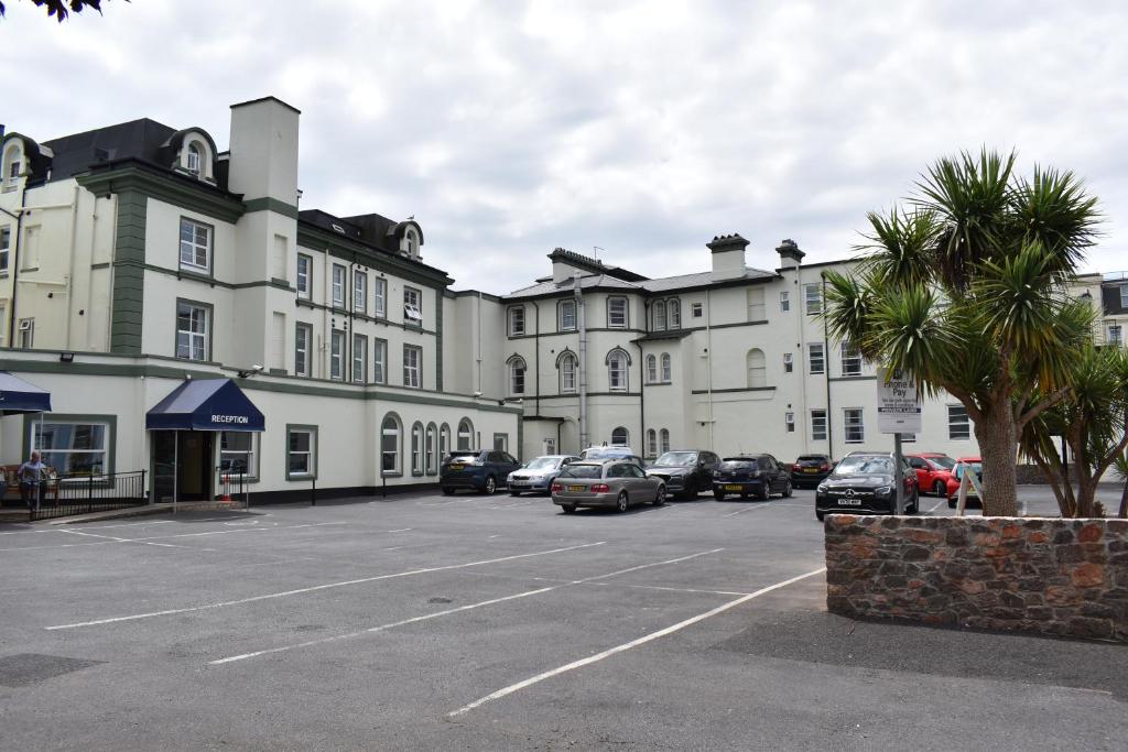 a large building with cars parked in a parking lot at Metropole Hotel in Torquay