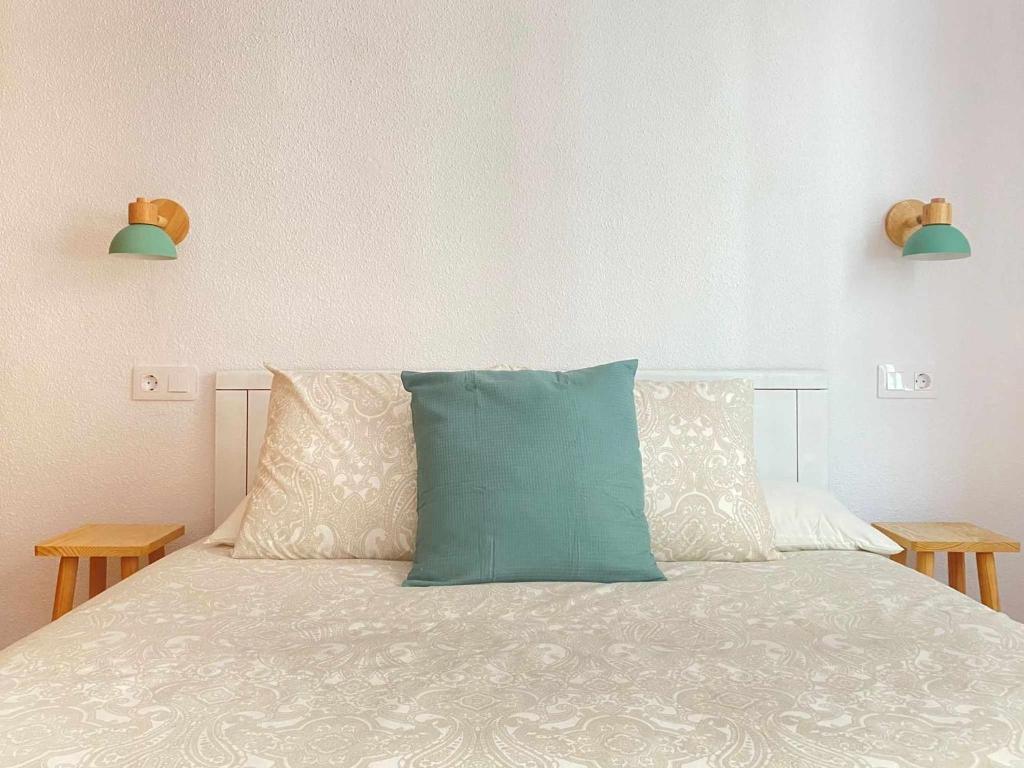 een bed met een blauw kussen erop bij Apartamento Ayla Catedral in Pamplona
