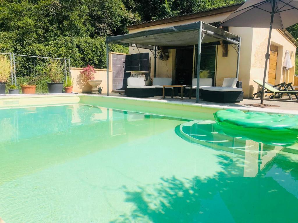 an empty swimming pool with an umbrella in a yard at Au repère de la Truffe in Campagne