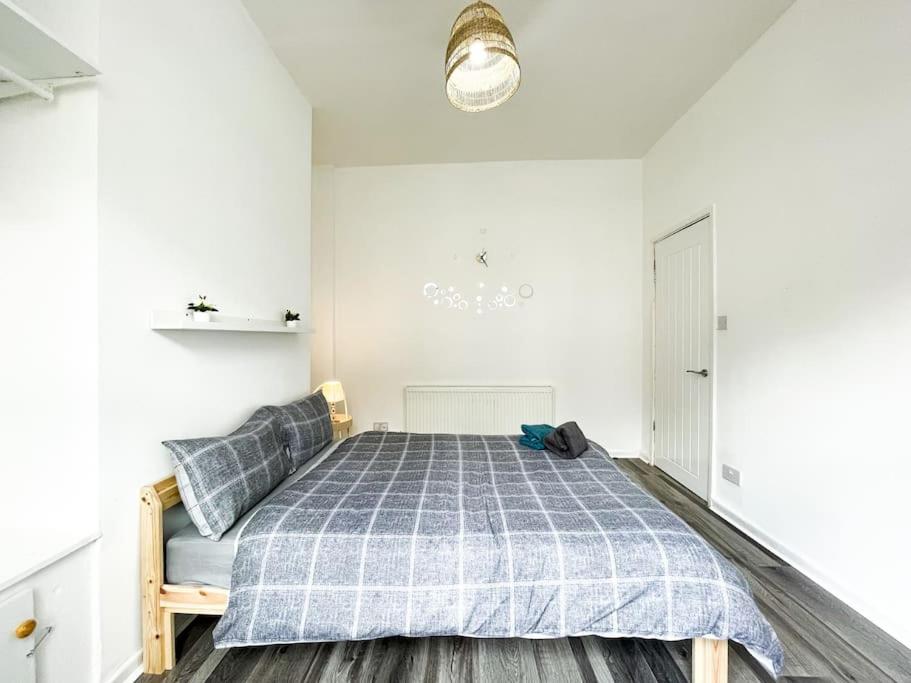 um quarto com uma cama com um cobertor azul controlado em Nicely Decorated 4BR, w/ Foosball Table and more! em Liverpool