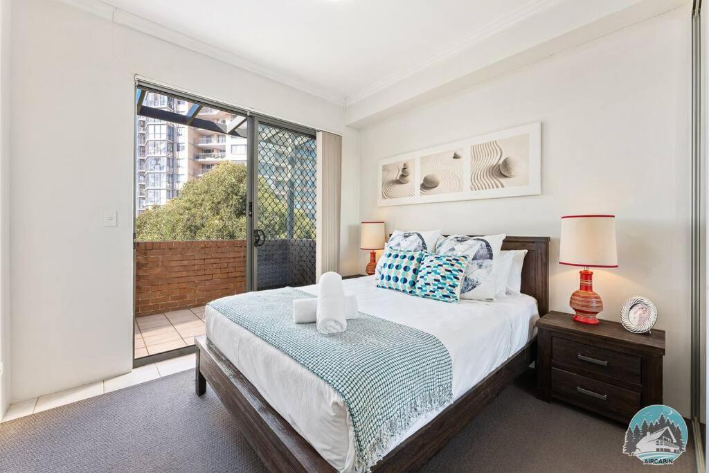 sypialnia z łóżkiem i dużym oknem w obiekcie Aircabin - Parramatta - Free Parking - 1 Bed Apt w mieście Sydney