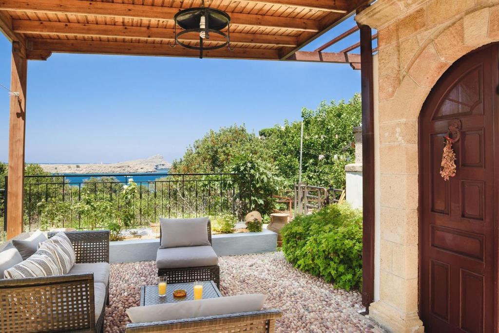 an outdoor patio with a wooden door and chairs at Welcoming Rhodes Villa 2 Bedrooms Villa Thea Stunning Sea and BBQ Lindos in Lindos