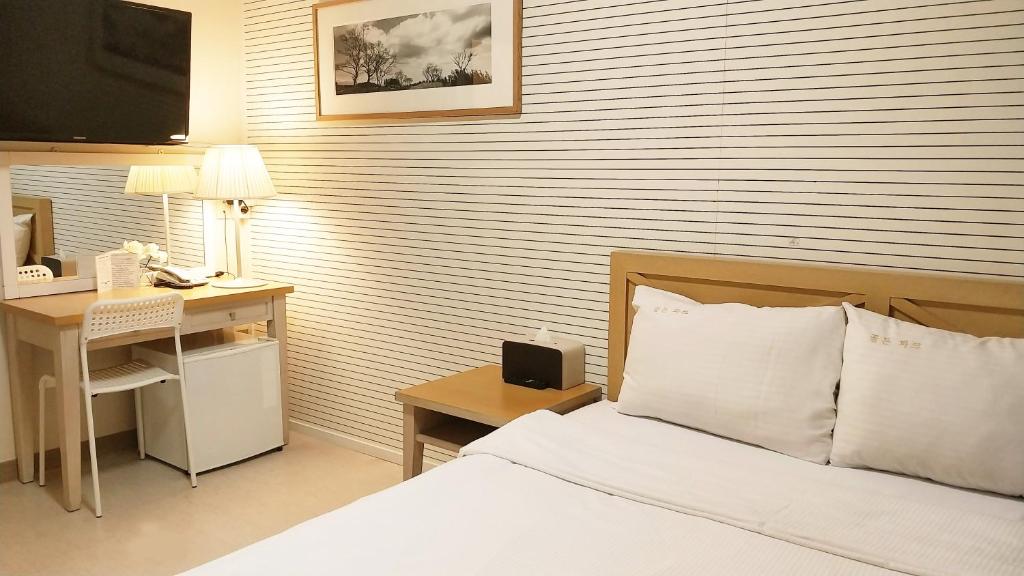 - une chambre avec un lit et un bureau avec un ordinateur dans l'établissement Golden Park Hotel, à Jeju