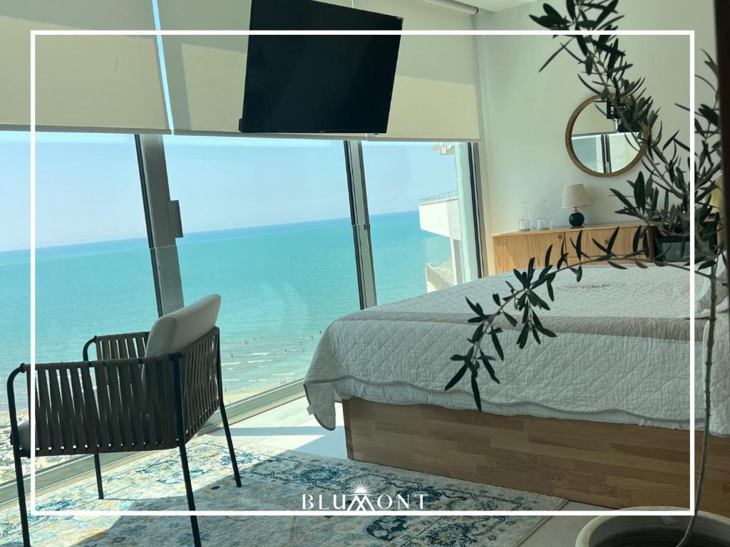 Luxury Rooftop Suites by Blumont في دوريس: غرفة نوم مع سرير وإطلالة على المحيط