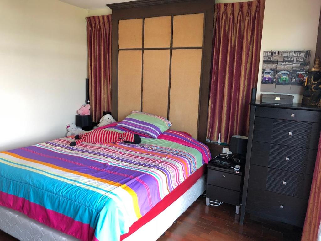 een slaapkamer met een kleurrijk bed en een dressoir bij The Seaside One Huahin in Hua Hin